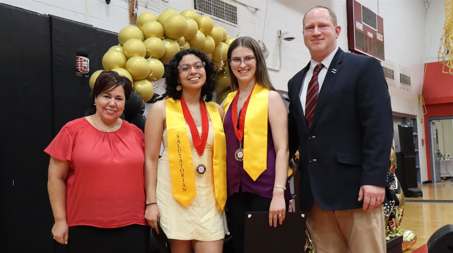 A group photo including the Chelsea Superintendent, high School Principal and two students wearing yellow stoles
